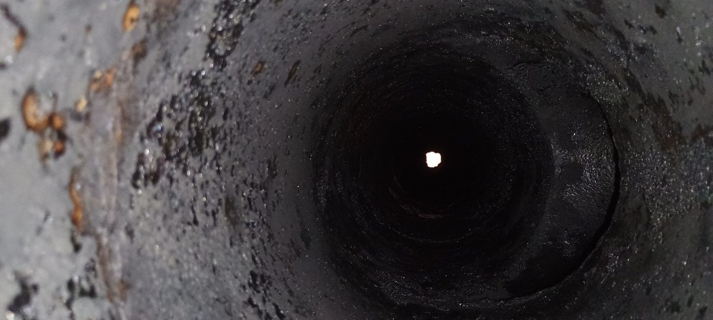 Zadehtovaný komínový průduch, stěny pokryté černým dehtem