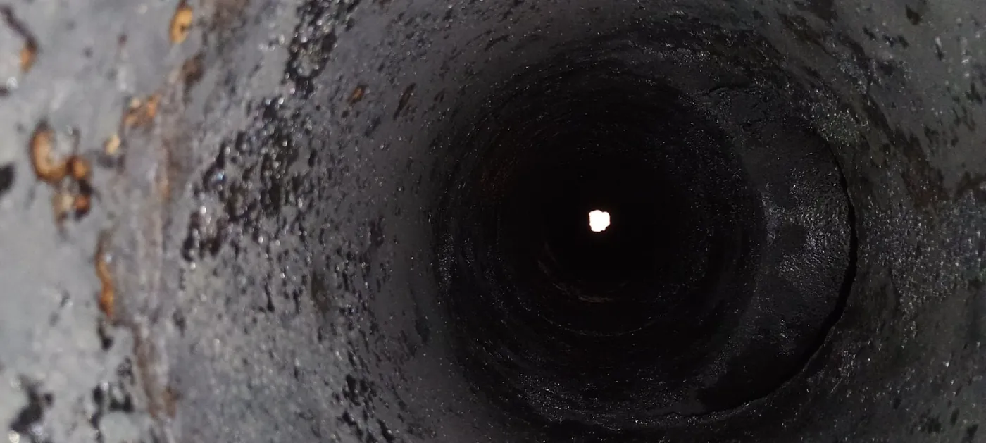 Zadehtovaný komínový průduch, stěny pokryté černým dehtem
